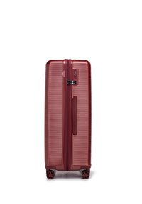 Valigia rigida rossa con texture a righe, chiusura con zipper, lucchetto a combinazione e quattro ruote girevoli per una maggiore mobilità.