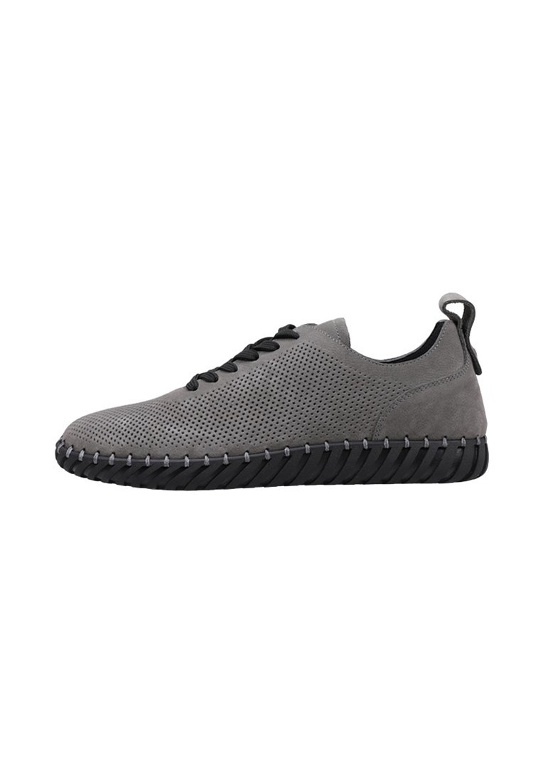 Zapatilla gris perforada con suela negra, que presenta una puntera redondeada y costuras en contraste. Incluye cordones negros y una lengüeta trasera.
