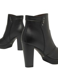 Un paio di stivaletti neri in pelle con tacco a blocco, dettagli metallici decorativi e il tricolore italiano sulla suola.