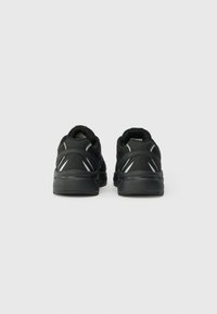 Pantofi sport negri cu un superior din plasă texturată și talpă din cauciuc. Dungi reflective pe călcâi și un guler căptușit pentru confort.
