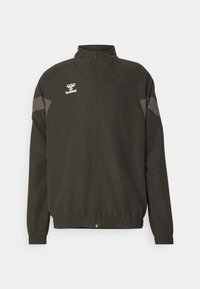 Svart vindjacka med hög krage, dragkedjestängning, elastiska ärmslut och grå detaljer på axlarna med logotyp på bröstet.