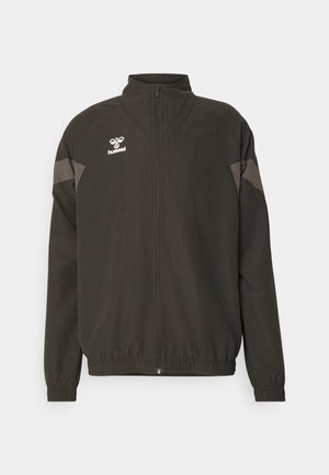 Schwarze Windjacke mit hohem Kragen, Reißverschluss, elastischen Bündchen und grauen Akzenten auf den Schultern sowie Logodetails auf der Brust.
