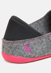 Chausson en feutre gris avec un talon en tissu noir, des accents roses et un logo. Comprend des coutures contrastantes et un dessus texturé doux.