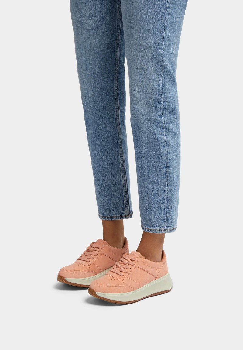 Lichtroze suède sneakers met een ronde neus, vetersluiting en een contrasterende witte zool. Draag ze met lichtblauwe jeans met omgeslagen pijpen.