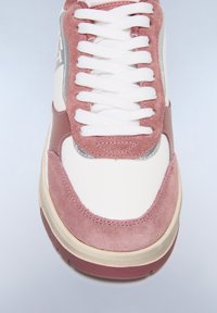 Vita sneakers med rosa mockadetaljer, texturerade överliggare och vita snörningar. Har en rundad tå och en lätt platåsål.