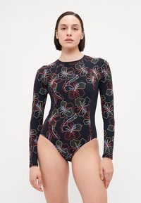 Maillot de bain à manches longues en noir avec des motifs floraux colorés. Présente un design ajusté et une texture lisse, adapté aux activités aquatiques.