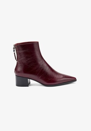 Stivale alla caviglia in pelle borgogna con punta affilata, tacco a blocco, zip laterale e finitura texture.