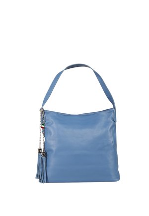 Sac à épaule en cuir bleu avec large bandoulière, pompon en chaîne argentée et petit pendentif drapeau italien sur fond blanc.