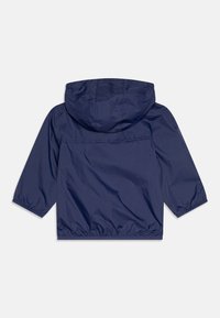 Giacca a vento blu navy con cappuccio, polsini elastici e cordoncino all'orlo, realizzata in materiale leggero e resistente all'acqua.