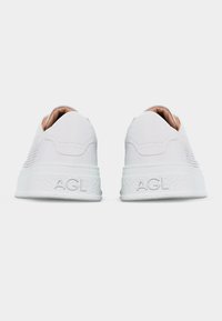 Ζευγάρι λευκά δερμάτινα αθλητικά παπούτσια, σε θέα από πίσω, με το "AGL" χαραγμένο στις υφασμένες λευκές σόλες και περφοραρισμένες πλαϊνές επιφάνειες.