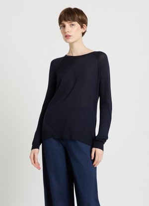 Pull bleu marine à manches longues en tissu tricoté léger. Il présente un col rond, des poignets côtelés et une silhouette décontractée.
