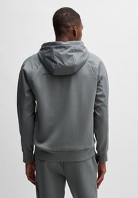 Grijze hoodie met een zachte textuur, met een relaxte pasvorm en geribde manchetten. Logo op de rug nabij de halslijn.
