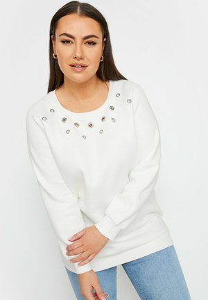 Sudadera blanca con escote redondo, que presenta detalles en plata y ojales en el pecho. Tejido suave, mangas de corte relajado y puños acanalados.