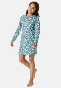 Langsleeve jurk in teal met een bloemmotief in witte, lichtblauwe en oranje vormen. Zachte stof met een losse pasvorm.