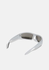 Sunglasses with a sleek, silver plastic frame and dark tinted lenses. Wraparound design with curved arms. CE marked for compliance.