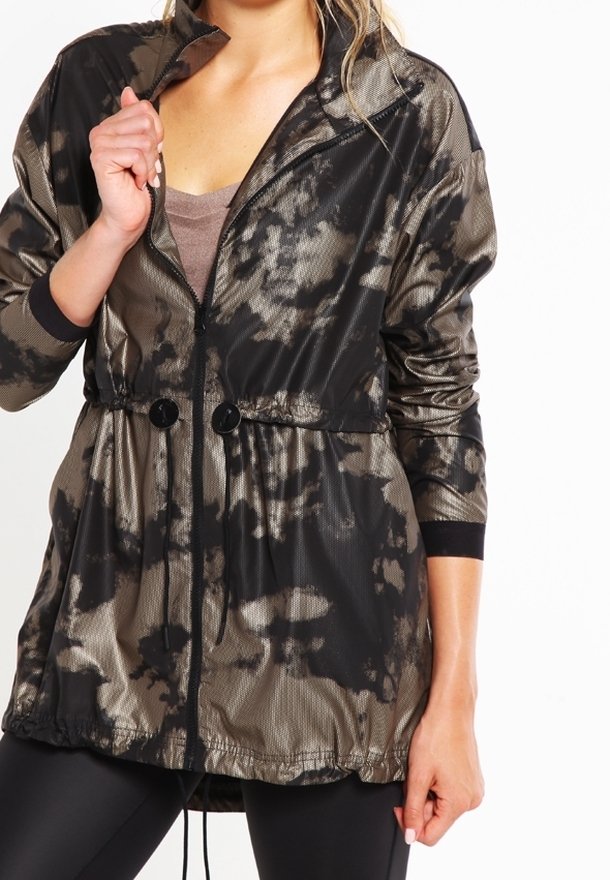 Vattenavvisande jacka i svart och taupe batikmönster. Har dragkedja framtill, elastisk midja och två framknappar.