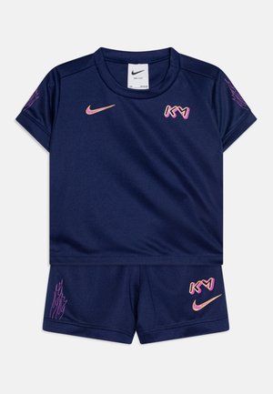 Conjunto atlético de color navy que incluye una camiseta de manga corta y pantalones cortos. Hecho de una tela suave, con detalles en rosa y logotipos en el pecho y los pantalones cortos.