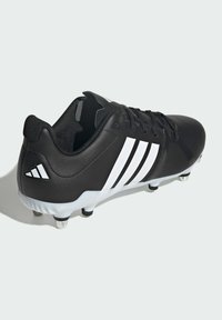 Černý fotbalový kopačk s bílými pruhovanými detaily a texturovaným povrchem, s kulatou špičkou, šněrovacím uzávěrem a pryžovou podrážkou s hroty.