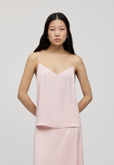 Lys rosa silke-camisole med tynne stropper og V-hals, med en avslappet passform og lett avrundet kant for ekstra flyt.