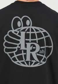 Černé tričko s velkým šedým grafickým designem globu se symbolickou rukou a textem "L R ab" stylizovaným uvnitř.