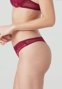 Burgunderfarbenes Spitzen-Höschen aus durchscheinendem Netz, mit einem tiefen Schnitt, glatter Textur und zartem Blumenmuster entlang des Bunds.