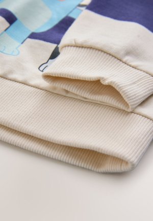 Hellbeiger Sweatshirt-Bündchen mit geripptem Muster und glatter Oberfläche, mit einem farbenfrohen Grafikmuster auf dem Hauptstoff.