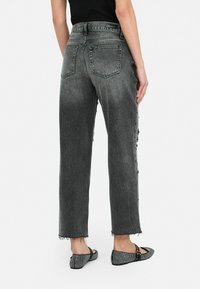 Grijze denim high-waisted jeans met een rechte pijp, rafelige zoom en twee achterzakken. Opvallende details zijn de zijdecoraties.