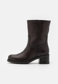 Stivale alla caviglia in pelle marrone con punta arrotondata, texture liscia e tacco a blocco moderato; presenta cuciture discrete e pannelli laterali.