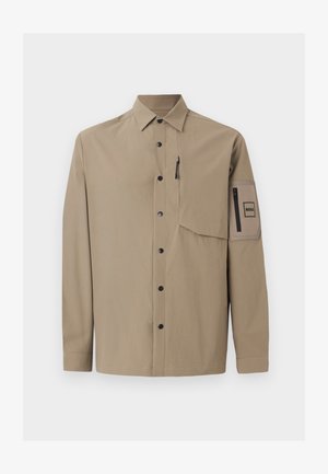 Bež košulja dugih rukava s kragnom, crnim snap gumbima, džepom na prsima sa zatvaračem i džepom s zakrpom sa zatvaračem na lijevom rukavu.