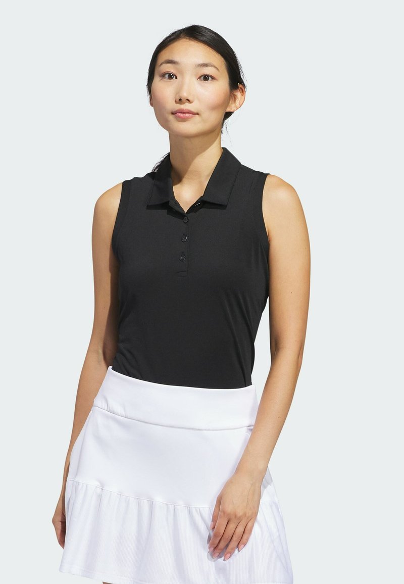 Top de polo preto sem mangas com gola, apresentando cinco botões. Combinado com uma saia plissada branca, feita de um tecido suave.