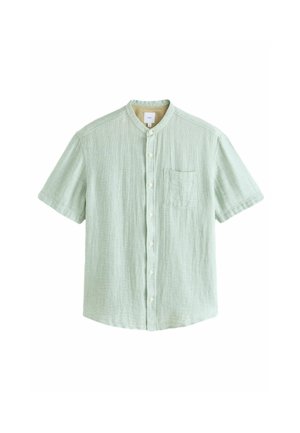 Camisa de manga corta en color verde claro, hecha de una tela texturizada, con un diseño de botones en la parte delantera y un bolsillo en el pecho.