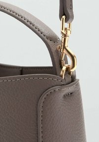 Siva kožna torba s teksturiranom površinom. Ima zlatne metalne detalje, kopču na kuku i pojačane šavove duž rubova.