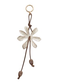 Ciondolo a forma di fiore in ceramica bianco sporco con dettagli dorati, appeso a un cordino marrone con due perline marroni.