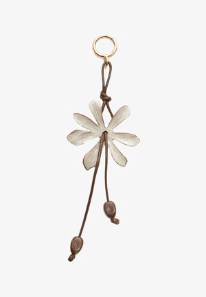 Flower-shaped charm in off-white ceramic with gold accents, hanging from a brown cord with two brown bead accents.