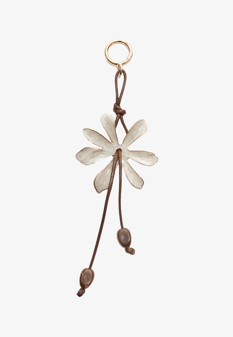 Ciondolo a forma di fiore in ceramica bianco sporco con dettagli dorati, appeso a un cordino marrone con due perline marroni.