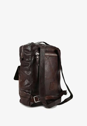 Zaino in pelle marrone dalla texture morbida, forma rettangolare, tracolla regolabile, scomparti con cerniera e dettagli in metallo.