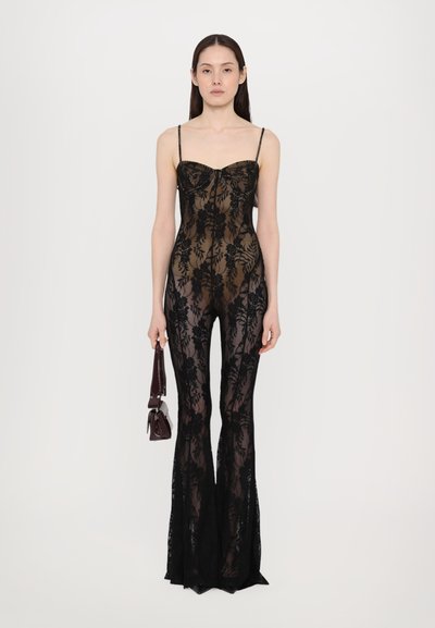 Salopetă neagră din dantelă, cu un corp ajustat, model floral și pantaloni evazați. Bretele subțiri ajustabile și un material transparent creează un efect în straturi.