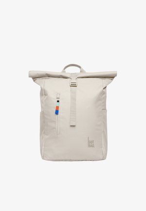 Beżowy plecak z rolowanym zamknięciem, z przednią pionową kieszenią na suwak, wyposażoną w kolorowe uchwyty oraz logo "GOT BAG" w prawym dolnym rogu.