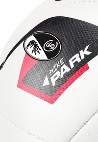 Pallone da calcio Nike Park con un design bianco e nero e superfici testurizzate. Logo notevole e accenti rossi sul pannello.