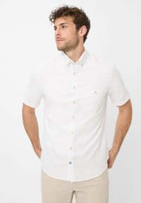 Korte mouwen witte overhem элп met lichte stof, voorzien van een borstzak en blauwe knoopdetails bij de kraag. Effen structuur.