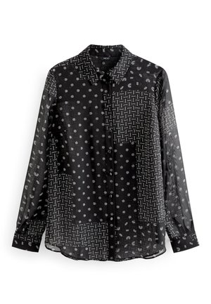Chemise noire transparente à manches longues avec motifs blancs variés : pois, zigzags et dessins abstraits. Boutons sur le devant et col classique.