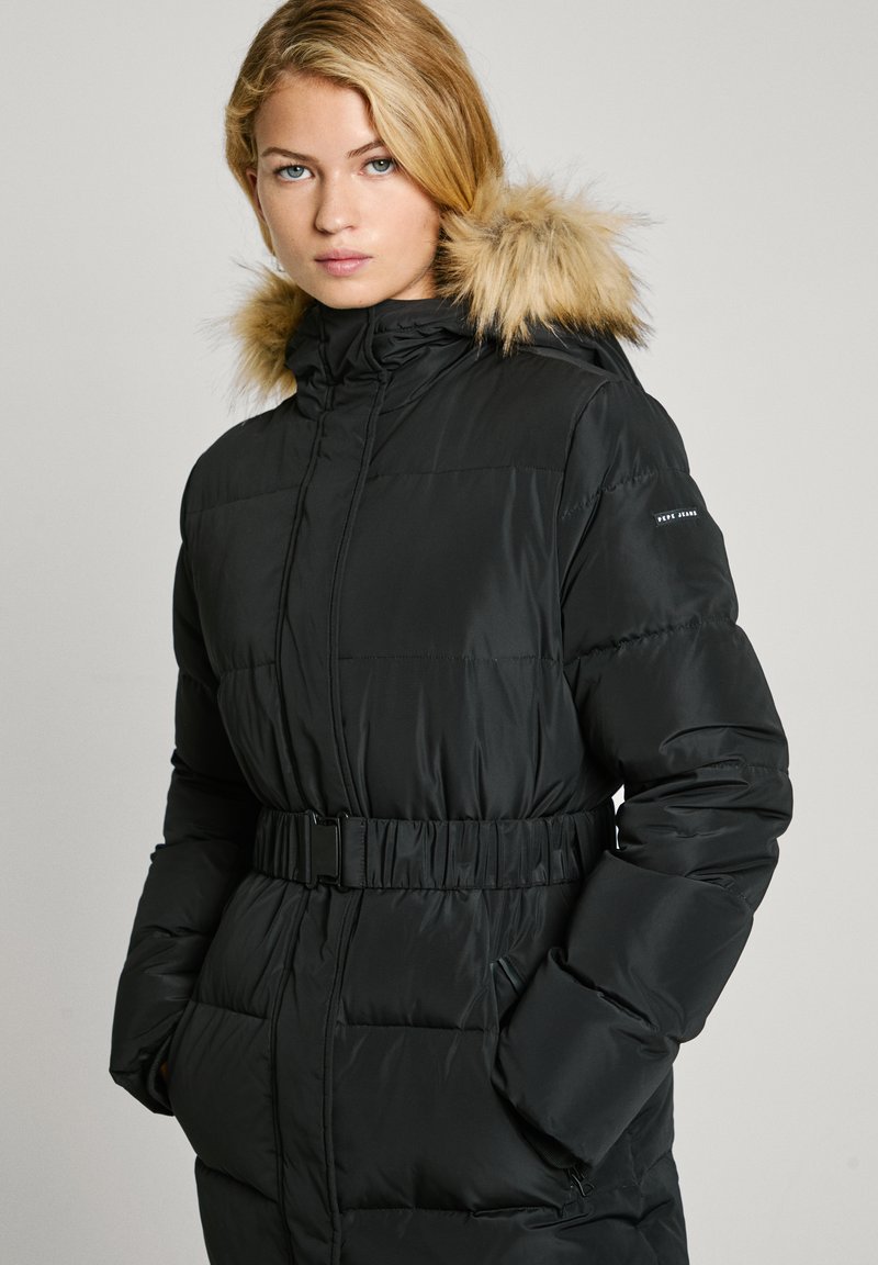 Parka nera imbottita con cappuccio foderato in pelliccia sintetica, vita cintata, chiusura con zip e tasche laterali; presenta una texture trapuntata e un tessuto liscio.