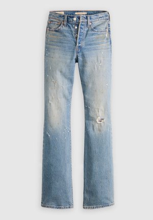 Jean bleu clair délavé avec braguette à boutons, légère décoloration et petite déchirure au niveau du genou droit, posé à plat sur un fond blanc.