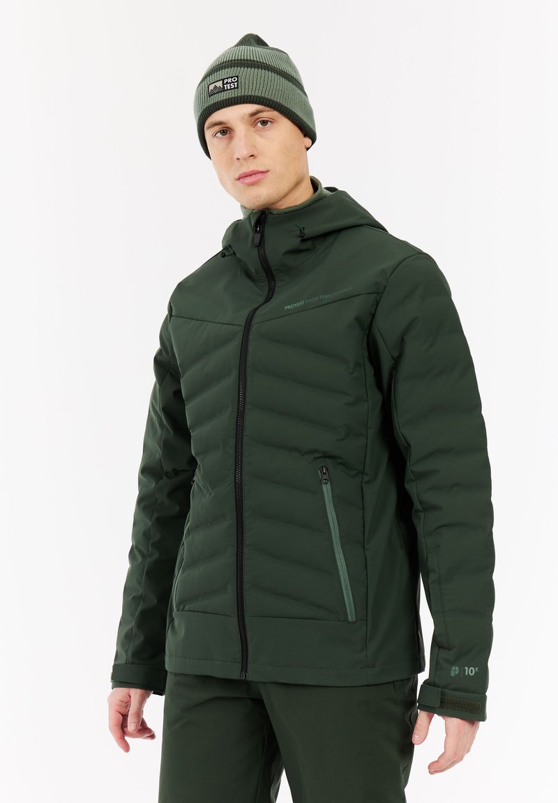 Tamsiai žalia pūkinė striukė su kapišonu, su įstrižai susegta medžiaga, šoniniu užtrauktuku, ir logotipo akcentais. Dėvima su derančia kepure.