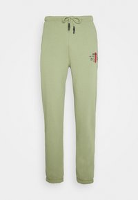 Ljusgröna sweatpants i mjukt tyg. Har justerbar dragsko i midjan, ribbade anklar och tryckta detaljer framtill.