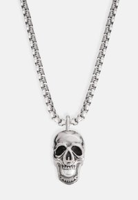 Collana in argento con un pendente a forma di teschio texturizzato, dotato di un dettaglio in perla lucida al centro e accenti neri attorno agli occhi.