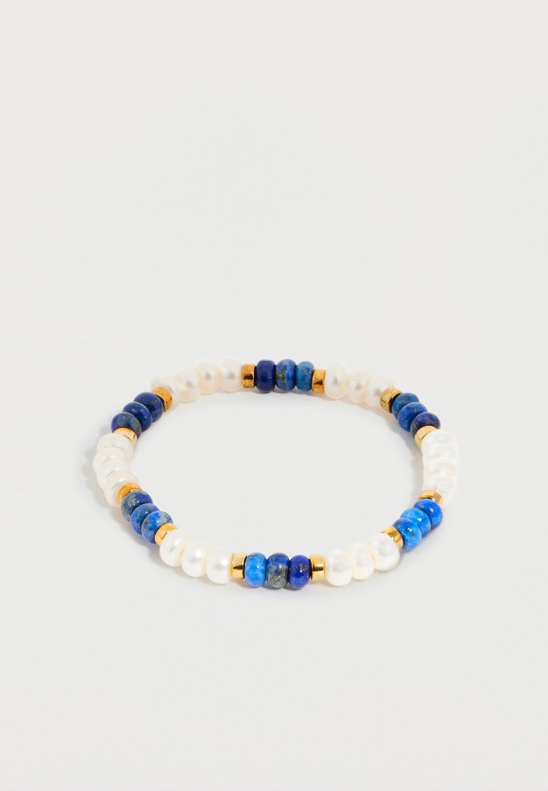 Dehnbare Armband mit abwechselnd blauen, weißen und goldenen Perlen, die in einem sich wiederholenden Muster auf hellem Hintergrund angeordnet sind.