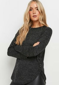 Zwarte, gemêleerde top met lange mouwen, afgeronde zoom, zijbuttonaccenten en een zachte textuur. Eenvoudig, casual ontwerp zonder patronen.