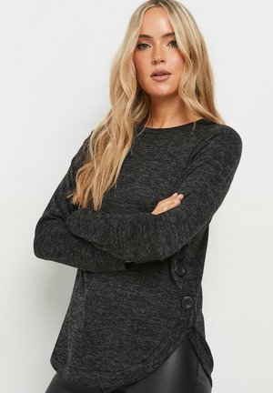 Black, heathered long-sleeve top with rounded hem, side button accents, and soft texture. Simple, casual design without patterns.
