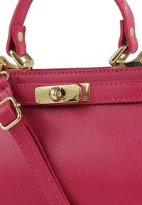 Felroze leren handtas met gouden beslag, een gestructureerde afwerking en een veilige sluiting. Voorzien van een afneembare riem voor veelzijdigheid.